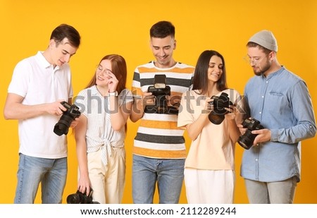Group of photographers on color background