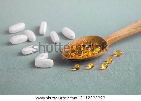 A complex of Mg  and vitamin D ( omega 3 ) capsules for treatment and human health on a light background. Copy space. Royalty-Free Stock Photo #2112293999