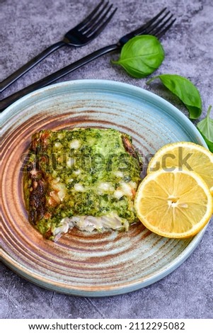 Fish bake refined with  spinach and gorgonzola cheese crust.White Code fish fillet stuffed  with broccoli  and  creamy Alfredo  sauce . Healthy food, delicious homemade italian  lunch .