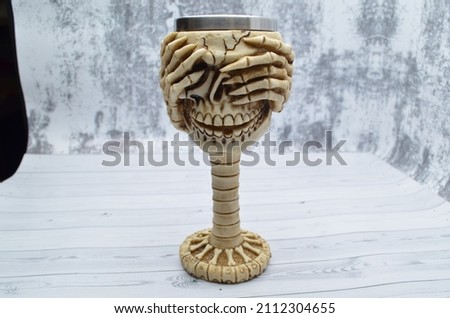 Volume cup in the form of a skull with closed eyes.