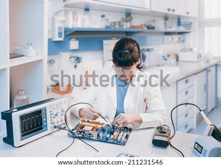 Young scientist repairs electronic device in modern laboratory