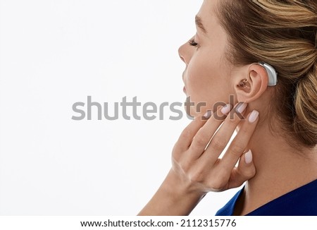 Hearing aids, hearing solutions. Woman enjoys a full life and can hear surrounding sounds thanks to a hearing aid behind her ear Royalty-Free Stock Photo #2112315776