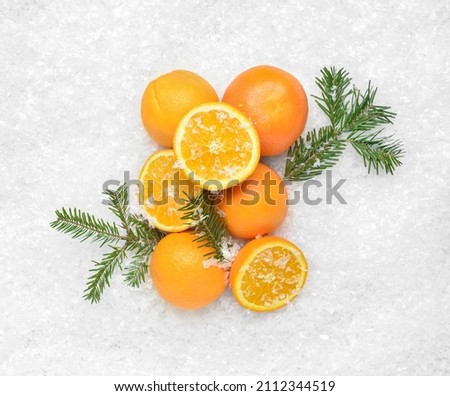 Fresh oranges and fir branches on snow