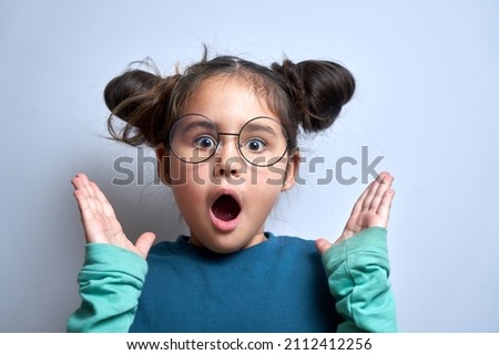 Funny little girl with shocked face and surprised open mouth closeup isolated on white background with copy space
