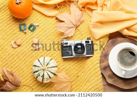 Stylish sweater, female accessories and cup of coffee on wooden background