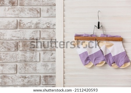 Hanger with stylish socks on folding screen