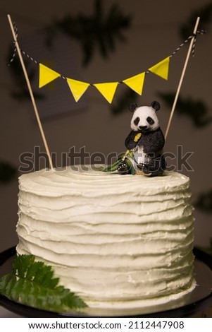 Birthday cake decorated with a banner and a panda toy