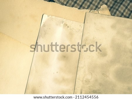 Old vintage photographs. Retro photo texture. Grunge background with old notebook and photos. Pile of old photos template cutout. Aged and yellowed postcard.