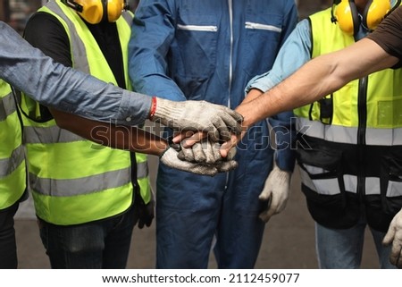 Group of technician engineer or worker in protective uniform with hardhat standing and stacking hands celebrate successful together or completed deal commitment at heavy industry manufacturing factory Royalty-Free Stock Photo #2112459077