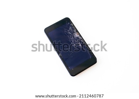 Black mobile phone with a broken screen on a white background. Black smartphone with a completely cracked screen after being dropped or hit does not work and needs to be repaired