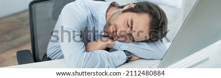 exhausted security man sleeping at workplace near computer monitor, banner
