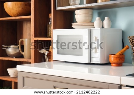 White microwave oven in interior of stylish kitchen