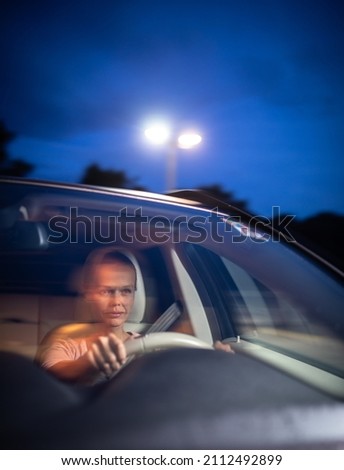 Young female driver at the wheel of her car, super tired, falling asleep while driving in a potentially dangerous situation - Road safety concept Royalty-Free Stock Photo #2112492899