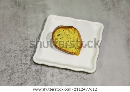 A piece of poppy seed cake served on a white plate.