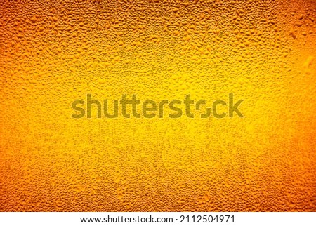 macro beer drink,Water drops background,Close up drops of a Ice Cold Pint of Beer- condensation. The background is clear with the emphasis on water drops on yellow-golden background.
