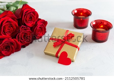 Happy St. Valentine's Day, Mother's Day, Women's Day greeting card. Red roses bouquet, gift box and candles on white background. Close up. Romantic present. Festive card design