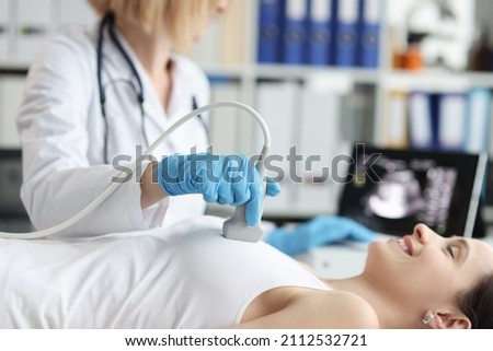 Doctor doing ultrasound examination of breast of patient in clinic Royalty-Free Stock Photo #2112532721