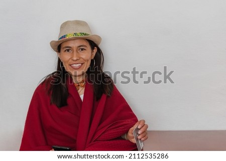 Latin peasant woman smiling sitting holding a credit card on white background