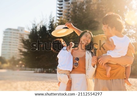 Cheerful Asian family travel at the beach.cute Asian boy playing with parents.