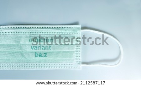  face mask with - Omicron variant ba.2 text on it. Covid-19 new variant - Omicron. Omicron variant of coronavirus. SARS-CoV-2 variant Royalty-Free Stock Photo #2112587117