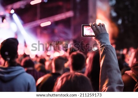 Close up of recording video with smartphone during a concert. Toned picture