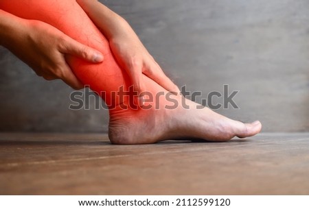 Inflammation of Asian young man leg. Concept of leg pain, tetany or calf muscle tenderness. Royalty-Free Stock Photo #2112599120