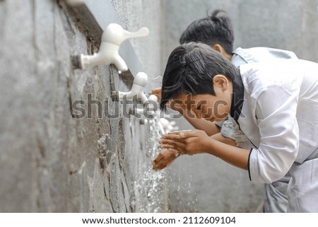 Close up An islamic boarding school students is doing ablution  Royalty-Free Stock Photo #2112609104