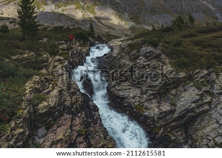 
A man near a small waterfall in the mountains