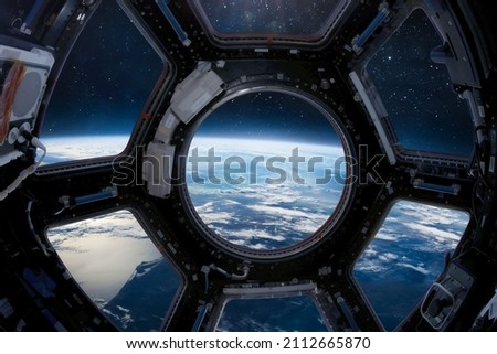 View from cupola module porthole of ISS space station on Earth and outer space. Sci-fi collage. Elements of this image furnished by NASA Royalty-Free Stock Photo #2112665870