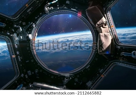 View from cupola module porthole of ISS space station on Earth and outer space. Sci-fi collage. Elements of this image furnished by NASA Royalty-Free Stock Photo #2112665882