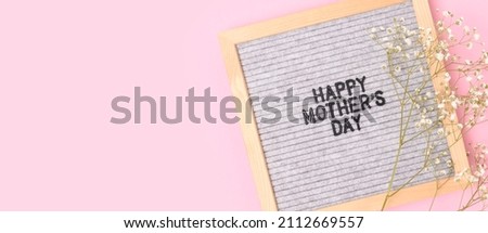 Happy Mothers day. Banner with letter board and gypsophila flower on a pink background. Festive concept.