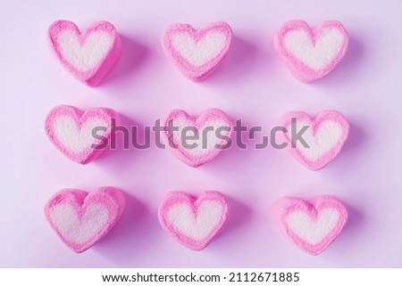 Rows of Pink and White Heart Shaped Marshmallow Candies on Pink Background