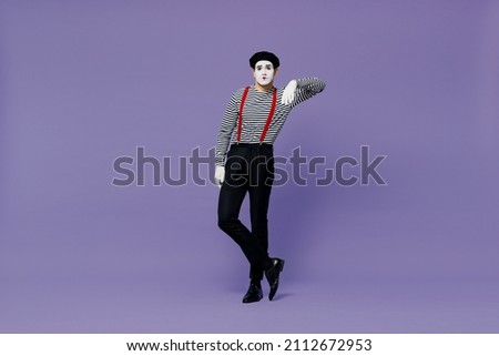 Full size body length confident young mime man with white face mask wears striped shirt beret look camera lean on something invisible isolated on plain pastel light violet background studio portrait Royalty-Free Stock Photo #2112672953