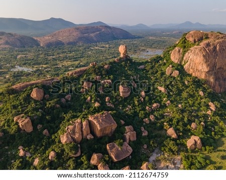 drone shot aerial view top angle bright sunny day rocky mountain hill valleys forest green trees plants hillocks tourism india tamilnadu madurai dense jungle foliage 