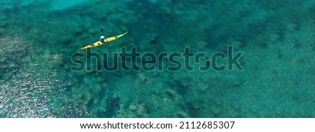 Aerial drone ultra wide panoramic photo with copy space of unidentified caucasian women paddling on tropical island exotic turquoise calm sea