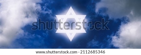 Star of David, symbol of Israel, shining on the sky amongst clouds. Royalty-Free Stock Photo #2112685346