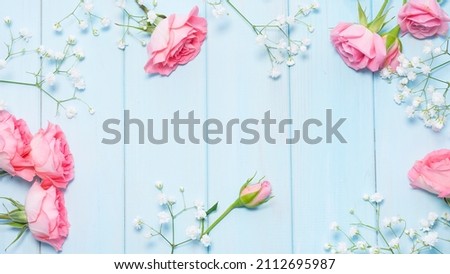 Delicate pink roses and gypsophila on a blue wooden background. Image with selective focus