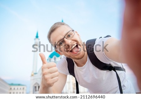 Happy man tourist make selfie photo on background of Kul Sharif Mosque Kazan Kremlin. Concept Travel Russia.