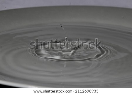 Falling and springing waterdrops with grey background