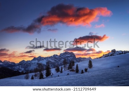 Scenic pictur of some pink clouds over a blue scenery at sunrise in Passo Falzarego, an alpine pass near Cortina d'Ampezzo, Dolomites, Italy