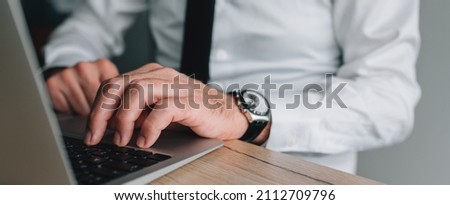 Data entry operator working on laptop computer in business office, panoramic image with selective focus