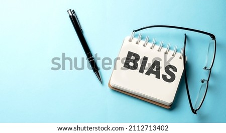 BIAS text written on a notepad on blue background