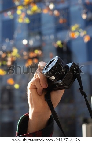 caucasian name hand with digital camera mirror less outdoors