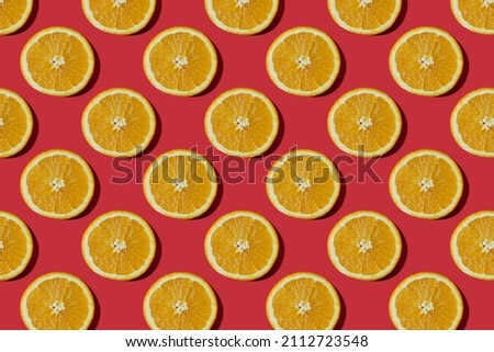 Summer composition made from oranges, on dark red  background. Creative Pattern made of slices of orange. Flat lay