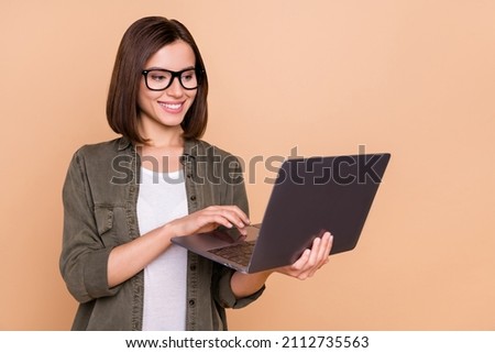 Photo of freelancer lady hold netbook read business report wear specs khaki shirt isolated beige color background Royalty-Free Stock Photo #2112735563