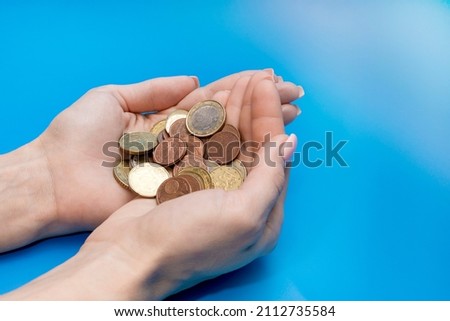 coins in the palms of a woman on a blue background. euro cents. High quality photo