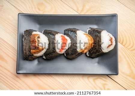 Onigiri or Japanese seaweed rice triangles shaped Stuffed with grilled eel, scallop, plum and fish roe, Japanese Rice Balls  famous food. Royalty-Free Stock Photo #2112767354