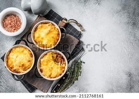 British dish Shepherd's pie with ground meat, mashed potato and cheddar cheese crust. White background. Top view. Copy space Royalty-Free Stock Photo #2112768161