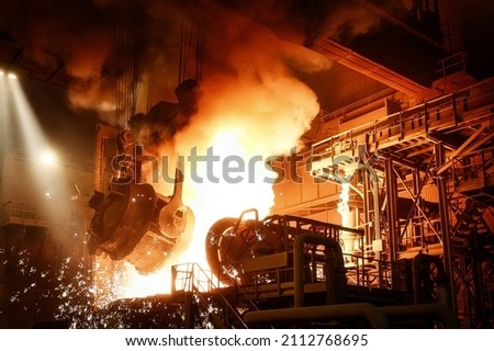 Liquid steel is poured from a metallurgical ladle Royalty-Free Stock Photo #2112768695