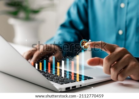 Businessman analyzing company's financial balance sheet working with digital augmented reality graphics. Businessman calculates financial data for long-term investment. Royalty-Free Stock Photo #2112770459